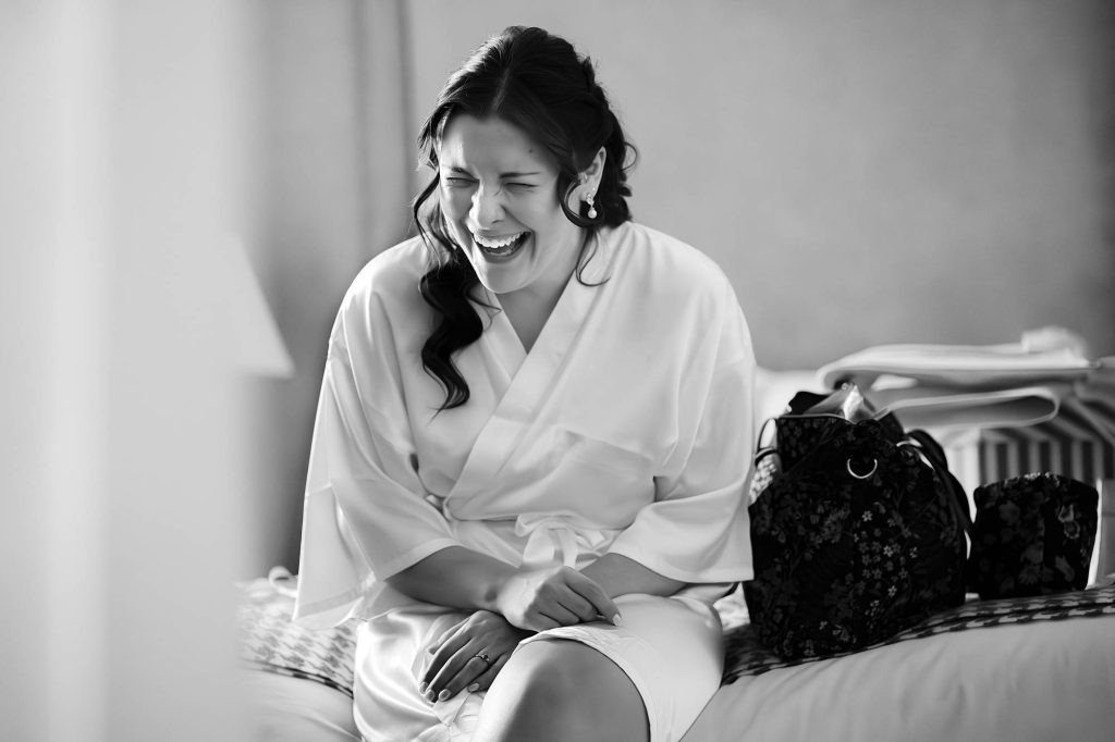 Bride candidly laughing during bridal prep